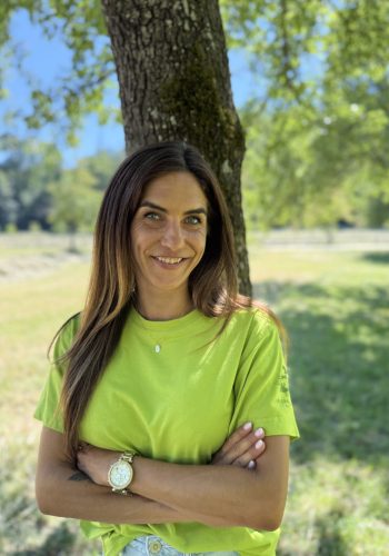 Eine Frau mit hellgrünem Shirt, die in die Kamera lächelt. Sie Mitarbeiterin.